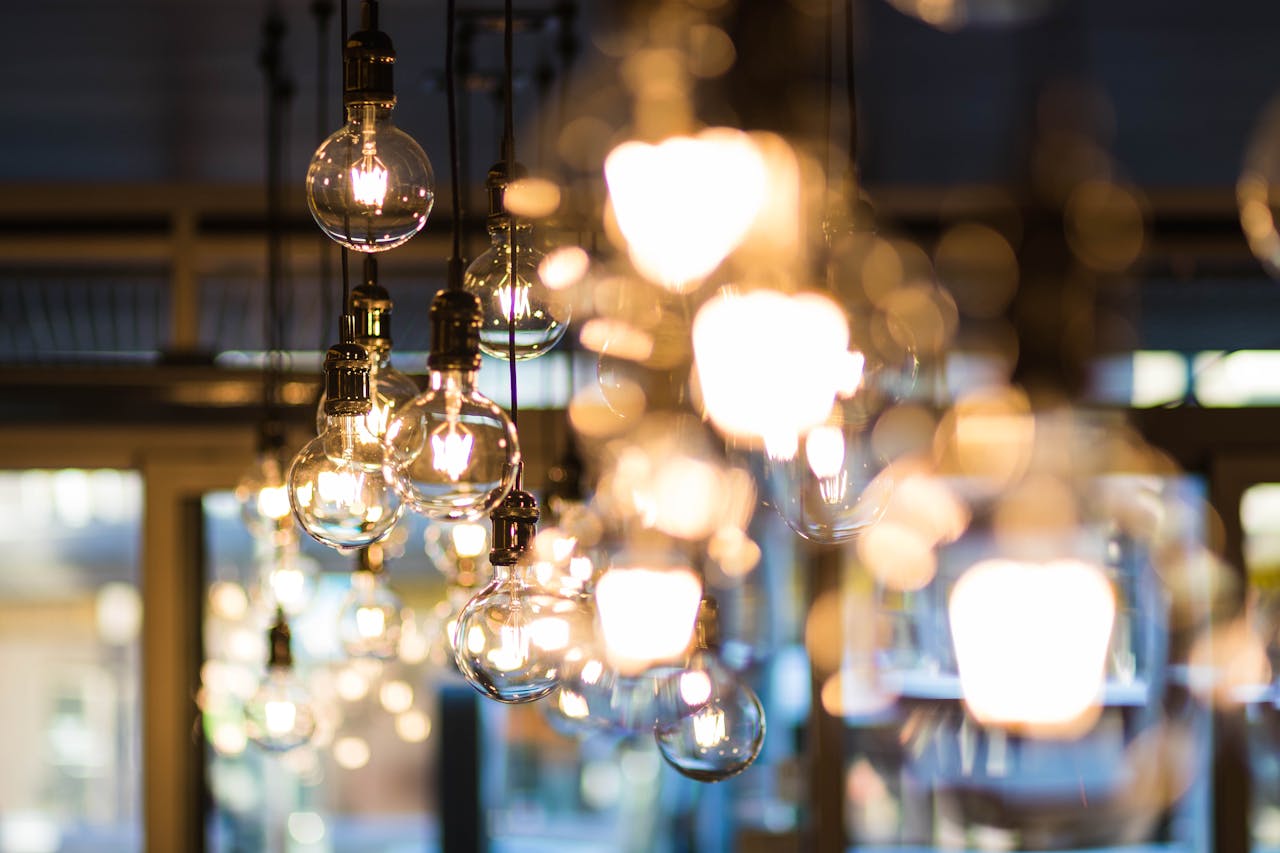 A modern and ambient urban setting with glowing, hanging light bulbs in focus.